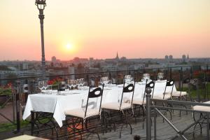 a table and chairs on a balcony with the sunset at Hotel Leopold I in Novi Sad