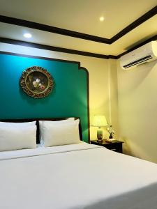 a bedroom with a white bed and a green wall at La Serena Boutique Hotel in Ho Chi Minh City