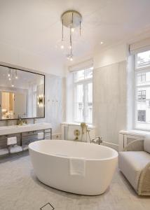 a large white bathroom with a tub and a sink at The Hotel Maria - Preferred Hotels & Resorts in Helsinki