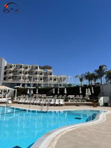 uma grande piscina com cadeiras e um edifício em Luxury Apartments - By Harim em Eilat