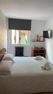 a bedroom with a large white bed with a window at Hotel Montecodeno in Varenna