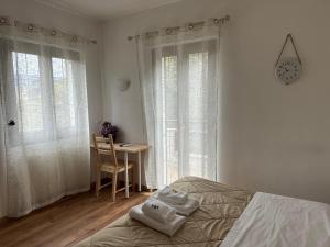 a bedroom with a bed and a table and windows at Hotel Al Verde in Mandello del Lario