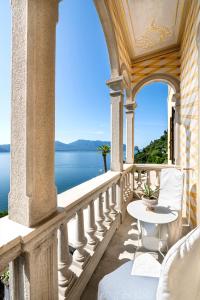 a balcony with a table and a view of the water at Hotel La Rondinella in Cannero Riviera