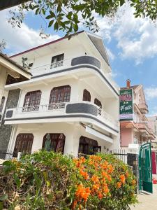 un bâtiment blanc avec un panneau devant lui dans l'établissement Dona Dalat Hotel, à Đà Lạt