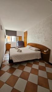 a bedroom with a large bed and a tiled floor at Hotel Montecodeno in Varenna