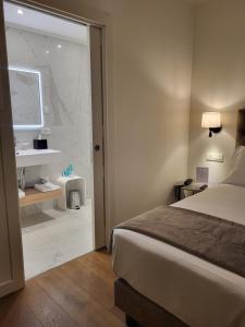 a hotel room with a bed and a bathroom at Sempione Boutique Hotel in Stresa