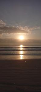 una puesta de sol en una playa con el océano en Mkuu House, en Malindi