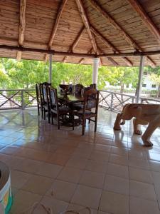 un comedor con una mesa y un perro en el suelo en Mkuu House, en Malindi