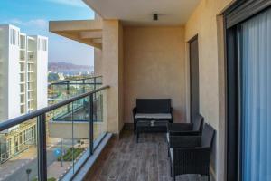 Suite Apartment #21 By Hashdera Eilat في إيلات: شرفة مع كراسي وطاولة على مبنى