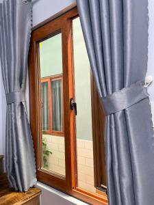 una ventana con cortinas azules delante de ella en Vania House comfortable studio near the airport, en Ho Chi Minh