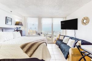 a bedroom with a bed and a couch at Harbour Beach Resort Unit 518 in Daytona Beach