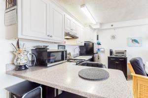 a kitchen with white cabinets and a granite counter top at Harbour Beach Resort Unit 518 in Daytona Beach