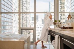 Duas mulheres numa cozinha a preparar comida. em SoHo Hotel Toronto em Toronto