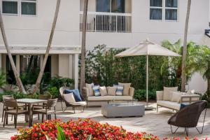 patio con sedie, tavoli e ombrellone di Courtyard by Marriott Miami Aventura Mall ad Aventura