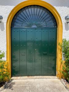 una gran puerta verde con techo azul en Cortijo Ribero, en Cabra