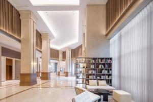 een lobby met een bibliotheek met een bank en een boekenplank bij Atour X Hotel Guangzhou Avenue South Pazhou Convention and Exhibition Center in Guangzhou