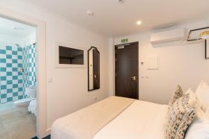 a bedroom with a bed and a bathroom at Westlight Lisboa Madalena in Lisbon