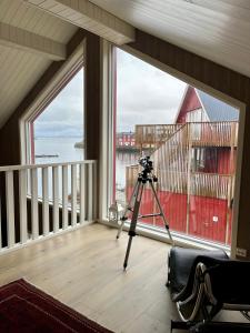 une caméra sur un tripod dans une chambre avec fenêtre dans l'établissement Finnvika Lodges, à Stamsund