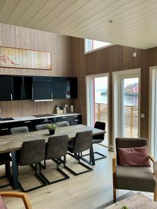 une salle à manger avec une grande table et des chaises en bois dans l'établissement Finnvika Lodges, à Stamsund