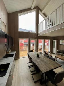 une grande salle à manger avec une table en bois dans la cuisine dans l'établissement Finnvika Lodges, à Stamsund