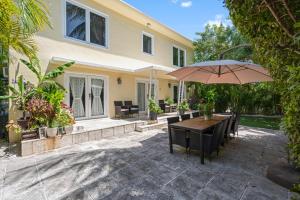 a patio with an umbrella and a table and chairs at villa venezia bb in Miami Beach