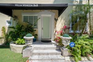 a front door of a house with two concrete vases at villa venezia bb in Miami Beach