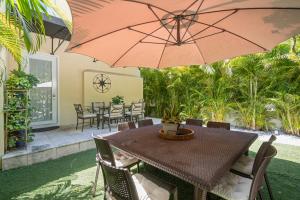 a table and chairs with an umbrella on a patio at villa venezia bb in Miami Beach