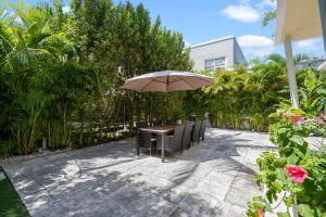 a table with chairs and an umbrella on a patio at villa venezia bb in Miami Beach