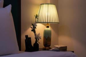 a lamp sitting on a table next to a bed at La Serena Boutique Hotel in Ho Chi Minh City