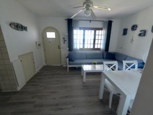 uma sala de estar com um sofá azul e uma mesa em Apartamento el Descanso em Son Bou