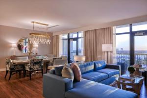 uma sala de estar com um sofá azul e uma sala de jantar em Hotel Effie Sandestin Resort, Autograph Collection em Destin