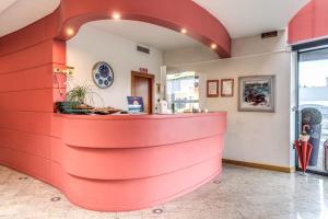 a restaurant with a red counter in a room at Luna Hotel Motel Lago Maggiore Arona in Oleggio Castello