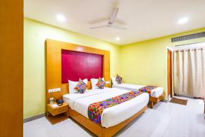 um quarto de hotel com duas camas e uma janela em FabHotel Prime Mahalaya Residency - Nr The Rajiv Gandhi Memorial & PVR Grand Galada em Chennai