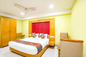 um quarto com uma cama e uma janela vermelha em FabHotel Prime Mahalaya Residency - Nr The Rajiv Gandhi Memorial & PVR Grand Galada em Chennai