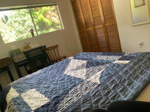 a bedroom with a blue and white quilt on a bed at GardenView queen-size bedroom in Redmond