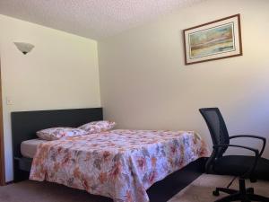 a bedroom with a bed and a chair at GardenView queen-size bedroom in Redmond