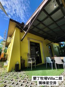 een huis met luifel, stoelen en een tafel bij 墾丁牧場Villa Kenting Pasture - Villa B&B in Kenting