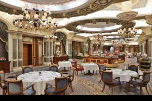 ein Restaurant mit weißen Tischen, Stühlen und Kronleuchtern in der Unterkunft The Ritz-Carlton Jeddah in Dschidda