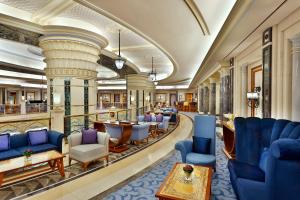 eine Hotellobby mit blauen Stühlen und Tischen in der Unterkunft The Ritz-Carlton Jeddah in Dschidda