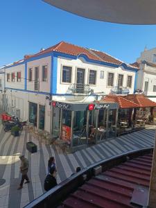 eine Gruppe von Menschen, die auf einer Straße mit Gebäuden spazieren in der Unterkunft Plaza Caparica Hostel in Costa da Caparica