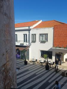 einen Innenhof in einem Gebäude mit Tischen und Stühlen in der Unterkunft Plaza Caparica Hostel in Costa da Caparica