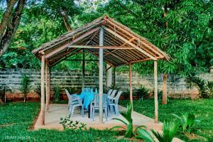 cenador de madera con mesas y sillas azules en PRIMESHADE GUESTHOUSE, en Malindi