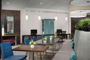 a waiting room with tables and blue chairs at Newly Renovated - Home2 Suites by Hilton Knoxville West in Knoxville