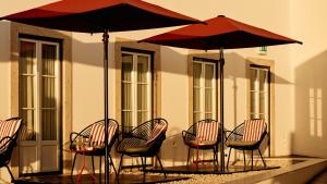 a group of chairs and umbrellas on a patio at Memmo Alfama - Design Hotels in Lisbon