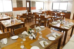 a large dining room with wooden tables and chairs at Sai Neem Tree Hotel in Shirdi