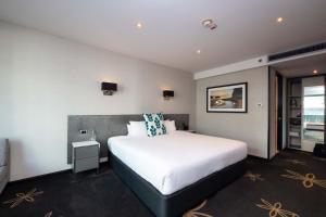 a bedroom with a large white bed in a room at SkyCity Hotel Auckland in Auckland