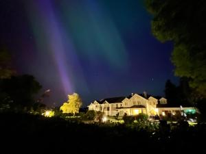 uma casa com um arco-íris por cima à noite em Loch Lein Country House em Killarney