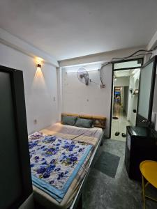 a small bed in a room with a mirror at Homestay 26 Nguyễn Văn Lạc in Ho Chi Minh City