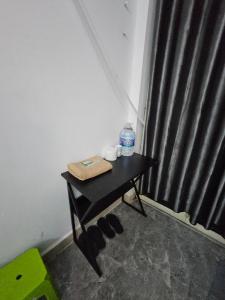 a small table with a bottle of water and shoes at Homestay 26 Nguyễn Văn Lạc in Ho Chi Minh City