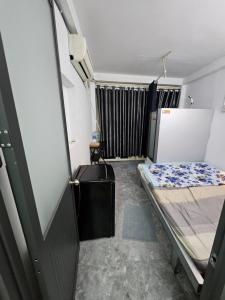 a small room with two beds and a door at Homestay 26 Nguyễn Văn Lạc in Ho Chi Minh City